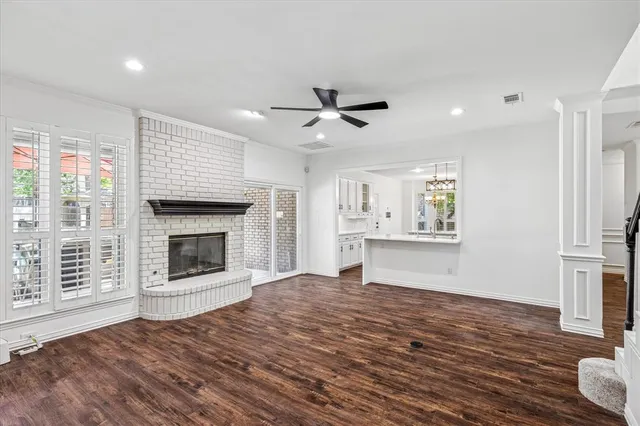 a view of empty room with wooden floor and fireplace