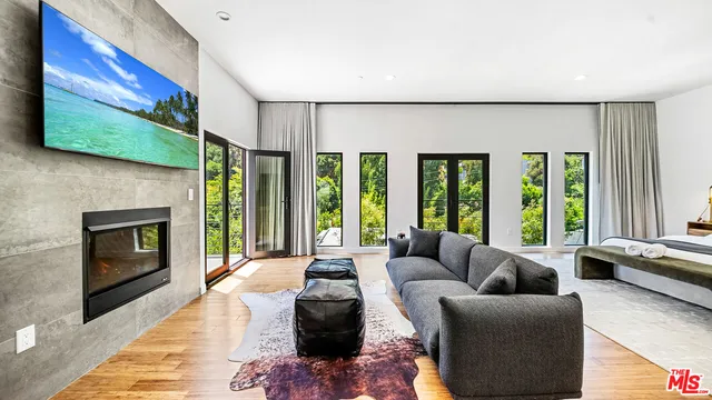 a living room with furniture large window and a fireplace