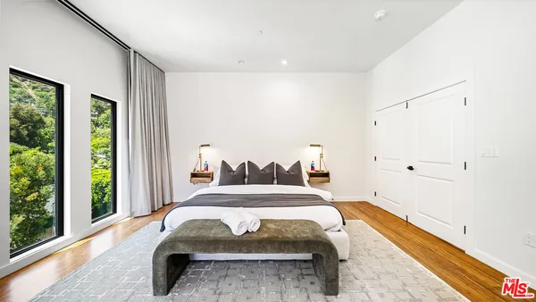 a spacious bedroom with a bed and a large window