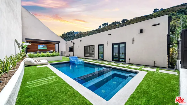 a view of an house with swimming pool and a yard