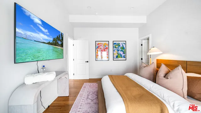 a bedroom with a bed and a flat screen tv