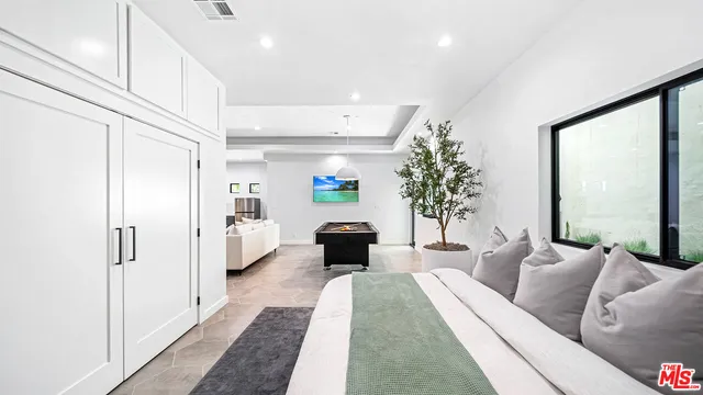 a living room with furniture large window and potted plants