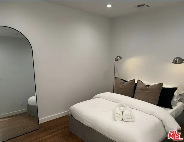 a bedroom with a bed and wooden floor