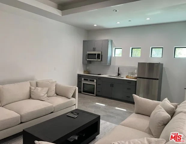 a living room with a couch and a view of kitchen