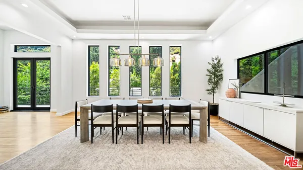 a view of a dining room with furniture large windows and wooden floor