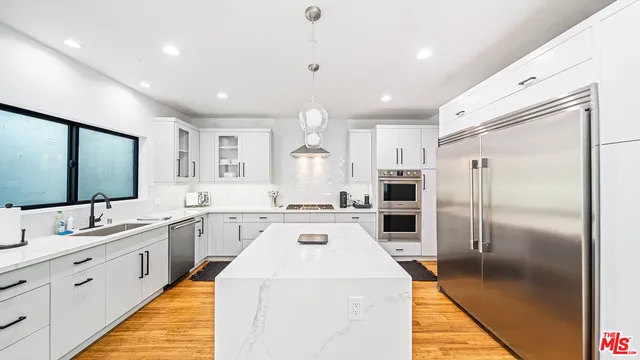 a large kitchen with a large counter top appliances and cabinets