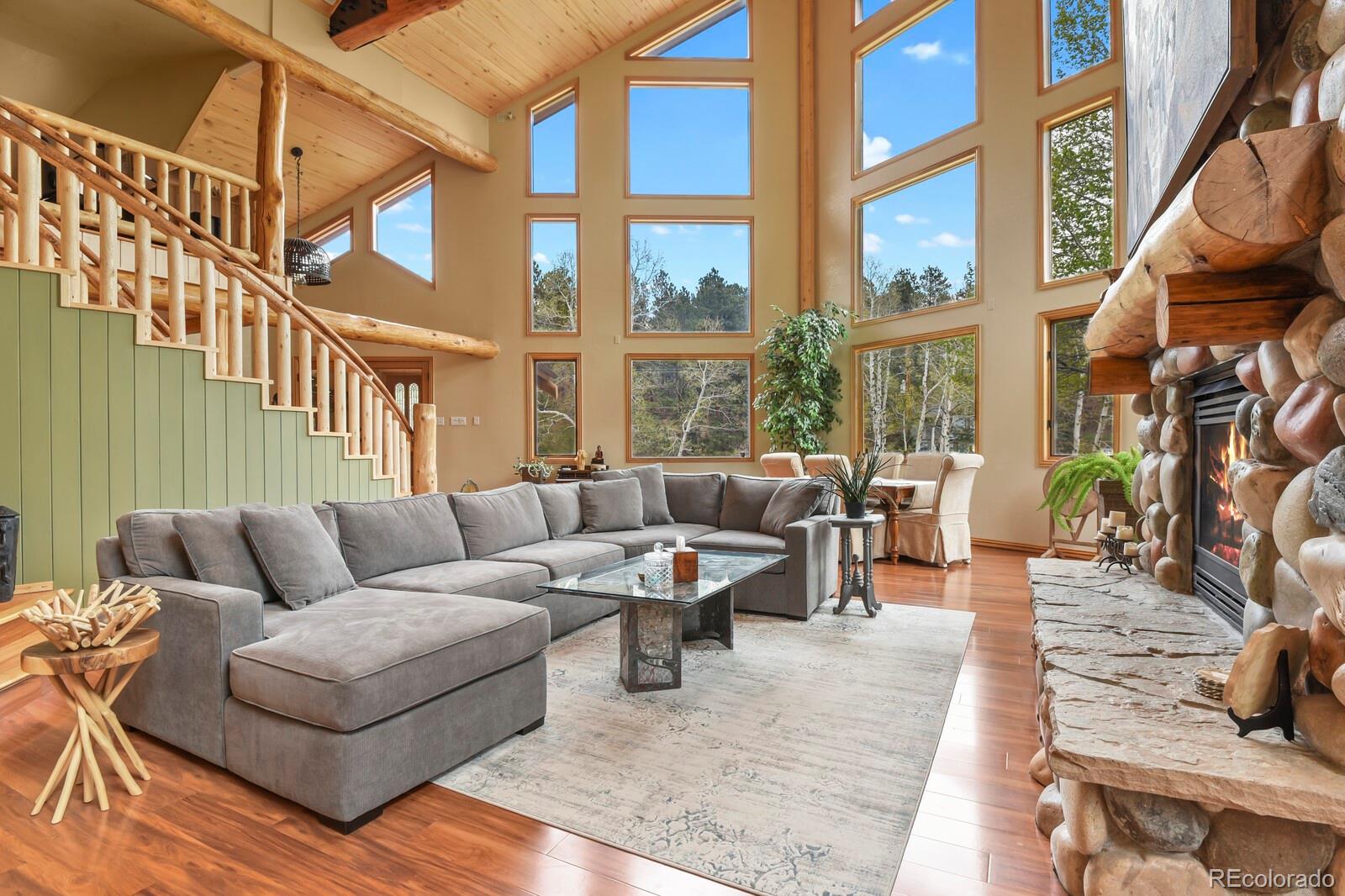 417 Witter Gulch Road Evergreen, CO 80439 - Photo 9 of 50 a living room with furniture a large window and wooden floor