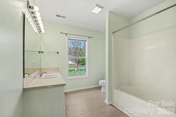 a bathroom with a tub a sink and a mirror
