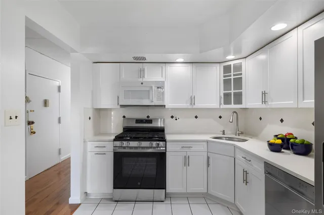 a kitchen with cabinets appliances a sink and a counter top space