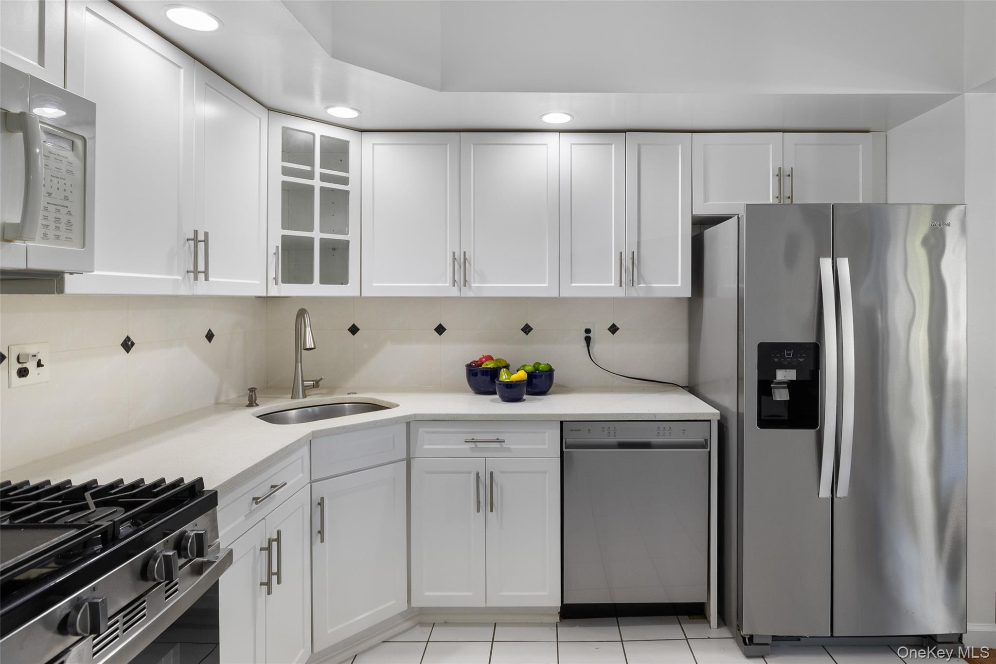 7111 Sutton Place, Unit 3 Queens, NY 11365 - Photo 14 of 27 a kitchen with white cabinets and appliances