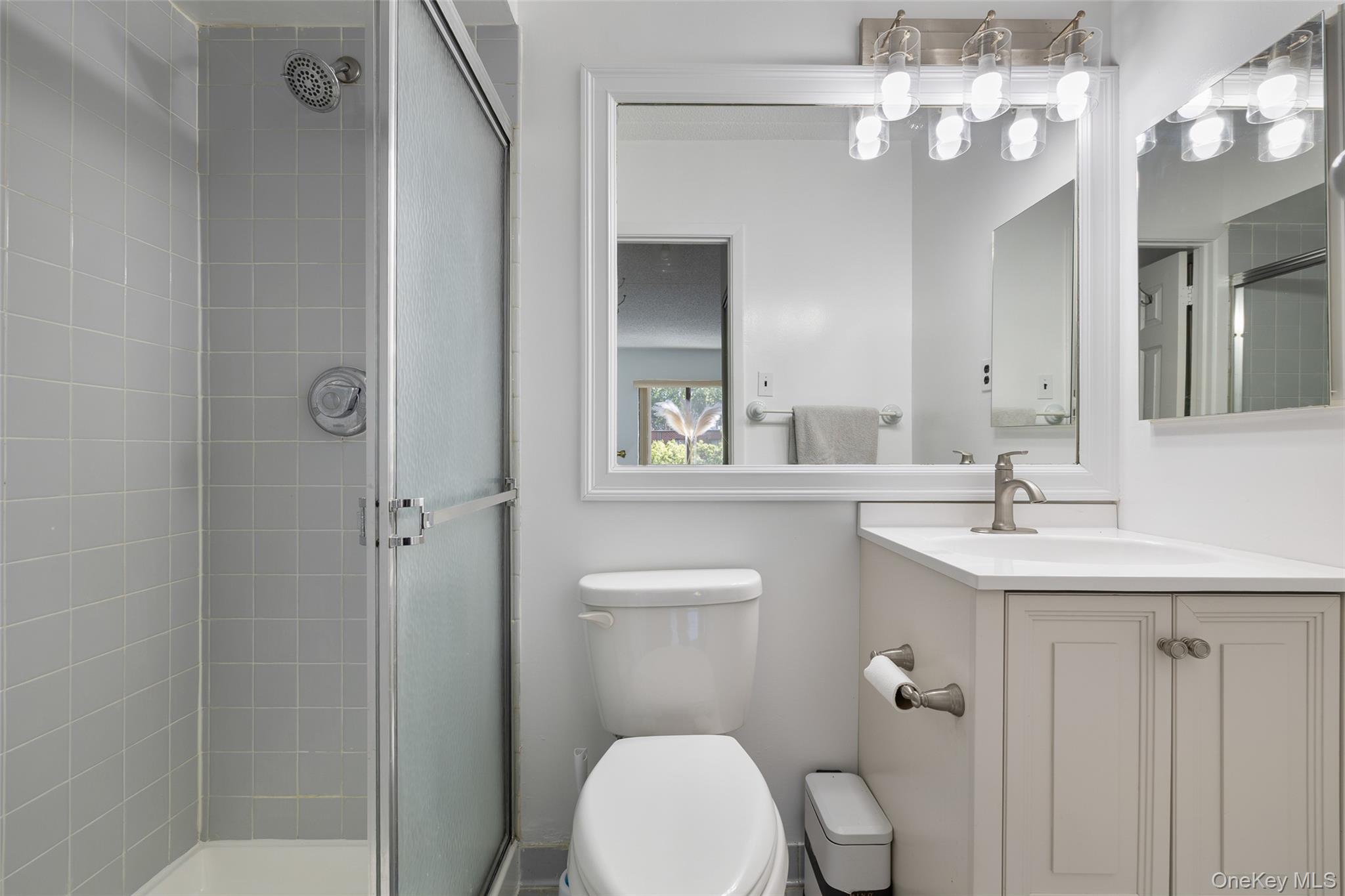 7111 Sutton Place, Unit 3 Queens, NY 11365 - Photo 16 of 27 a bathroom with a toilet a sink and mirror