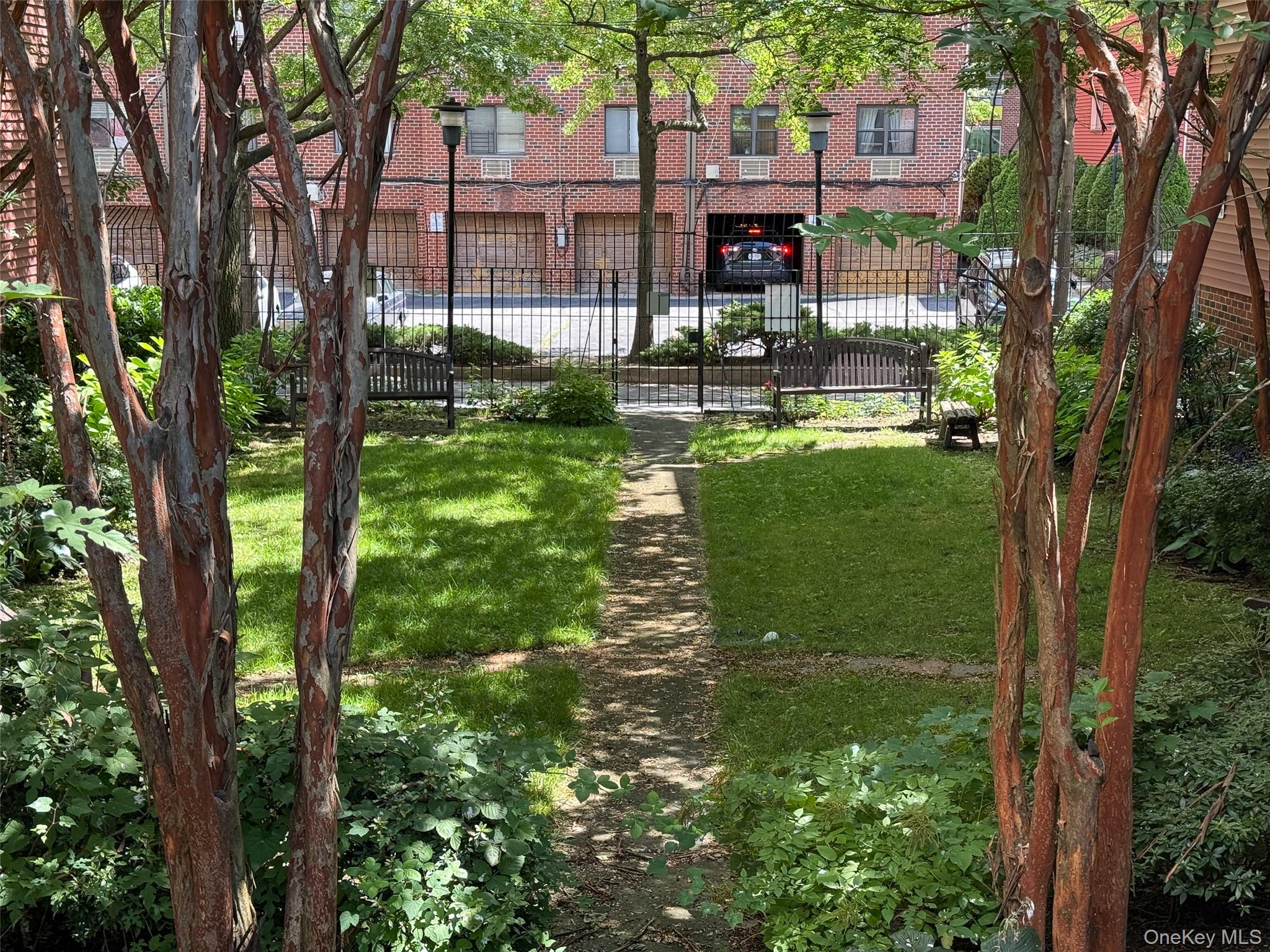 7111 Sutton Place, Unit 3 Queens, NY 11365 - Photo 27 of 27 a backyard of a house with lots of green space and fountain