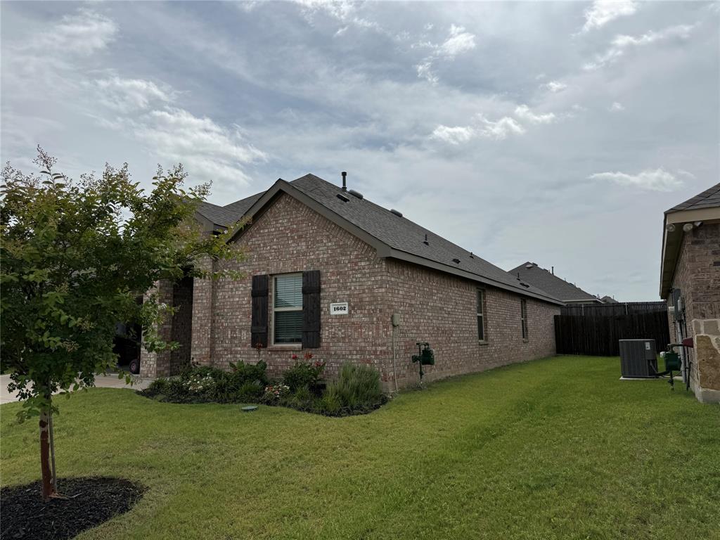 1602 Maple Ridge Drive Princeton, TX 75407 - Photo 2 of 13 Brick exterior with dark shutters, gabled roofline, and attached fencing