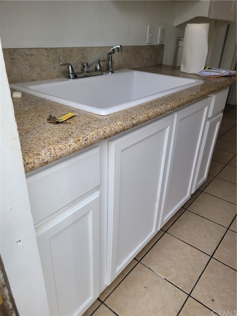 3077 Lemon Street Riverside, CA 92501 - Photo 16 of 20 a bathroom with a granite countertop sink and washing machine