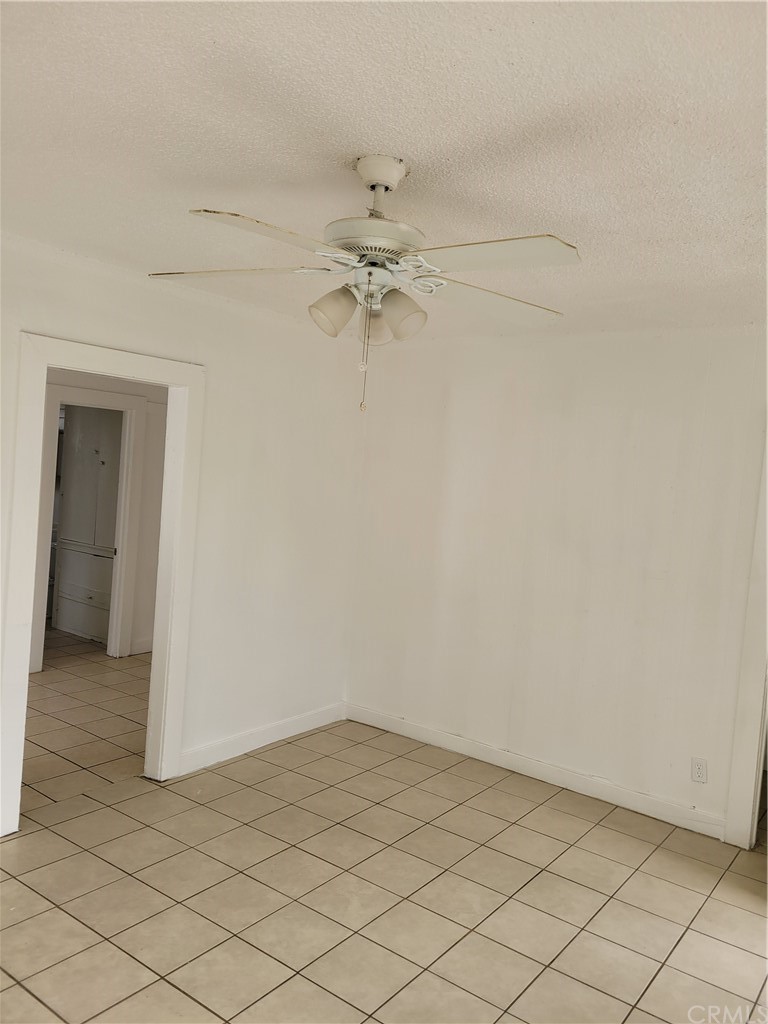 3077 Lemon Street Riverside, CA 92501 - Photo 8 of 20 an empty room with a ceiling fan and carpet