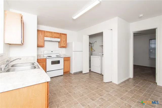 a kitchen with a stove a sink and a refrigerator