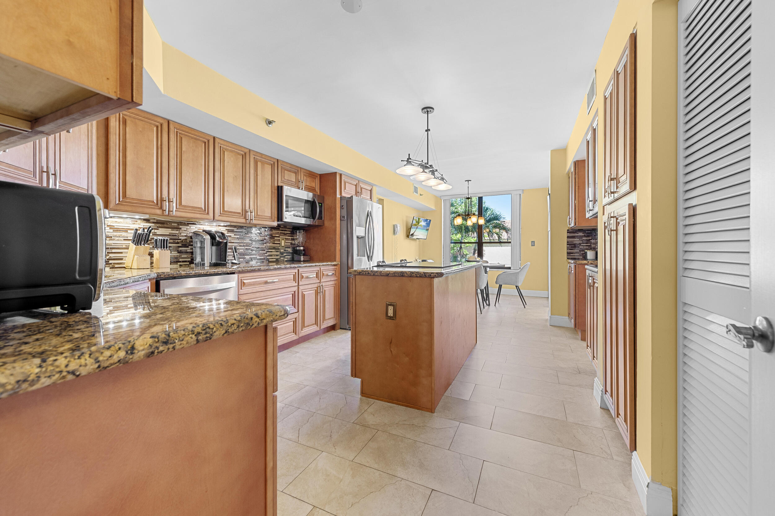 7209 Promenade Drive, Unit 201 Boca Raton, FL 33433 - Photo 13 of 41 a kitchen with stainless steel appliances granite countertop a refrigerator a stove and a sink with wooden floor