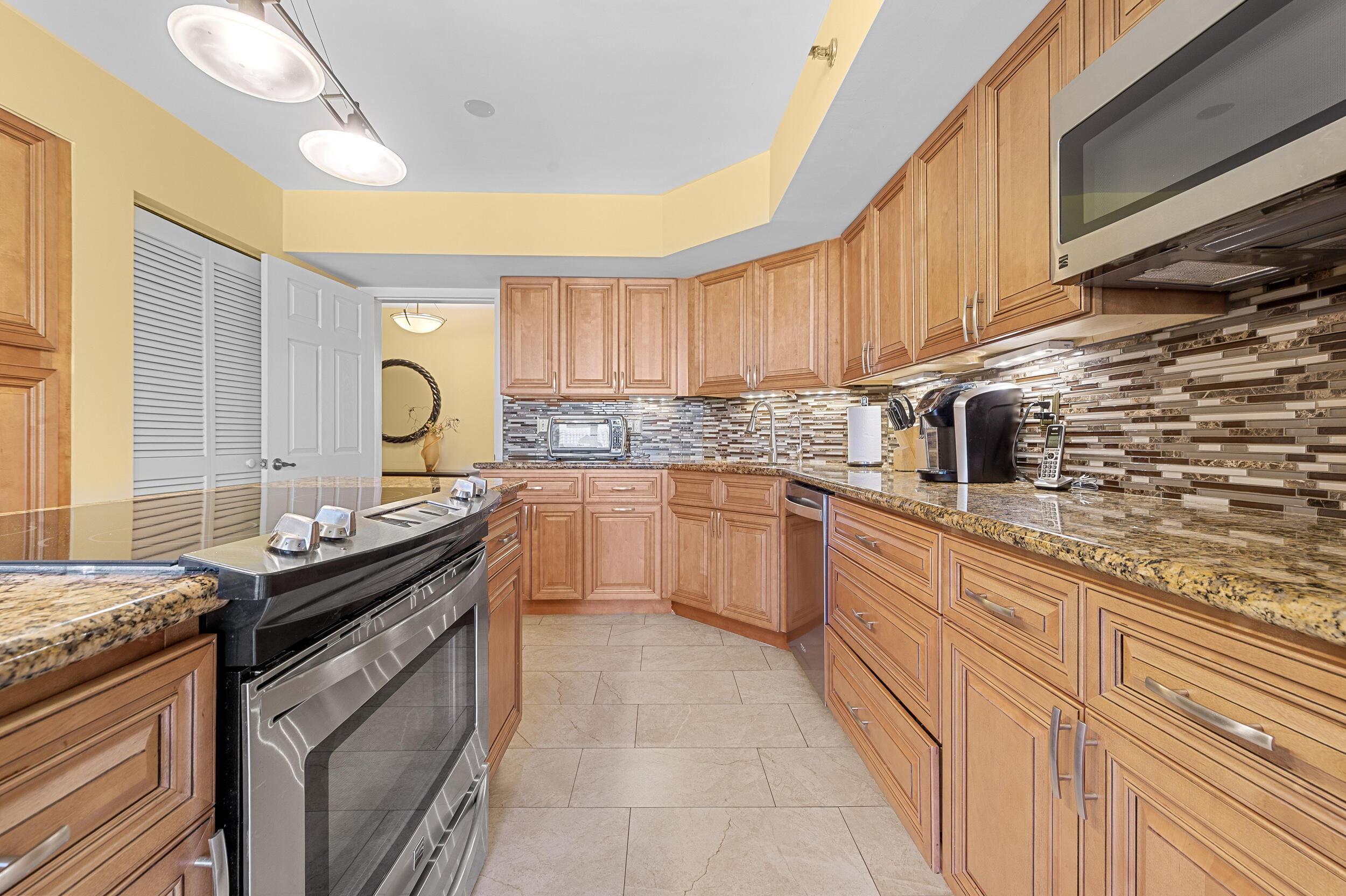 7209 Promenade Drive, Unit 201 Boca Raton, FL 33433 - Photo 18 of 41 a kitchen with a sink stove and cabinets
