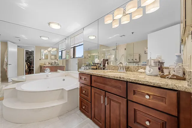 a large white kitchen with kitchen island a sink stainless steel appliances and cabinets