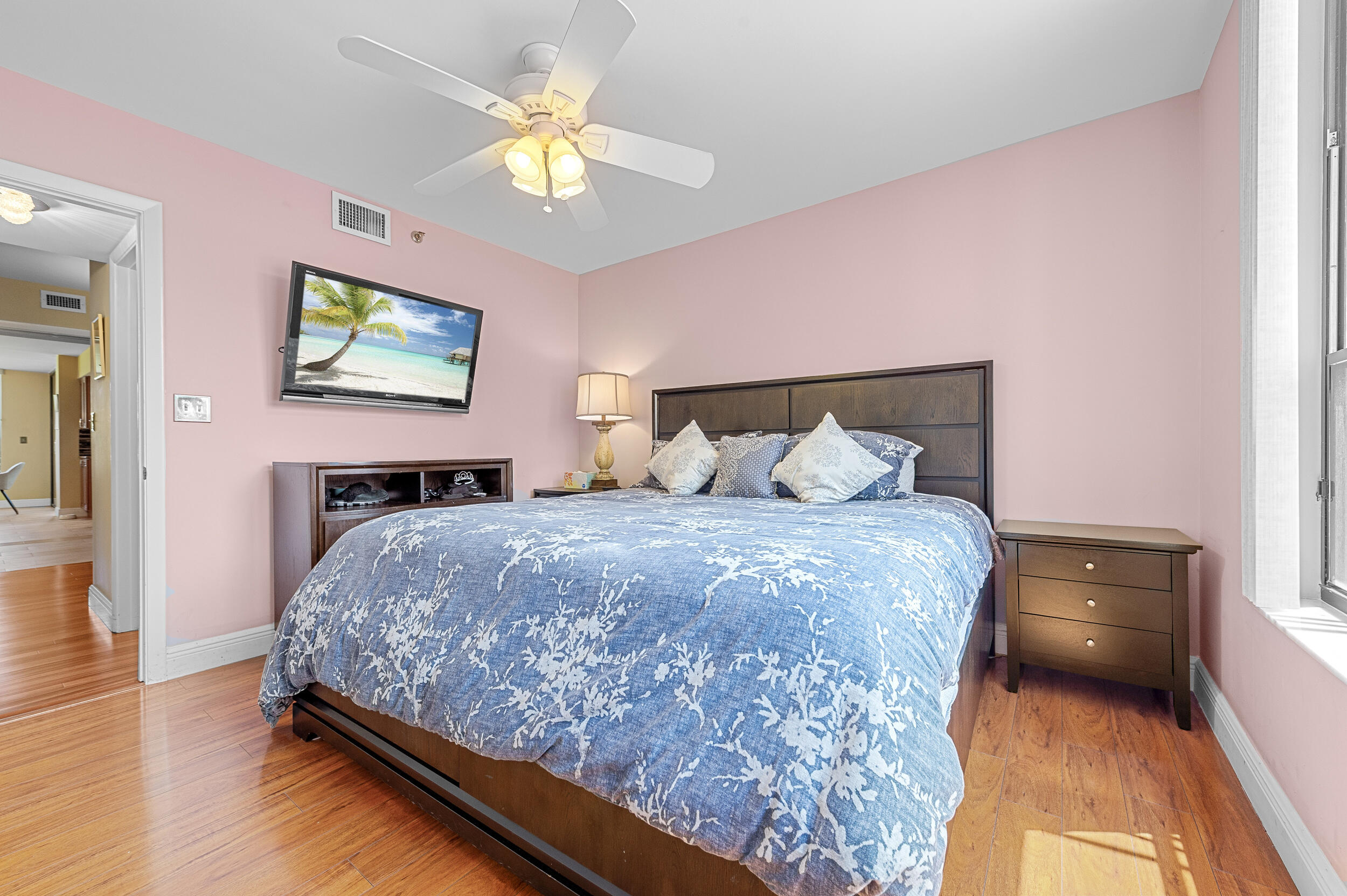 7209 Promenade Drive, Unit 201 Boca Raton, FL 33433 - Photo 30 of 41 a bedroom with a bed and a chandelier