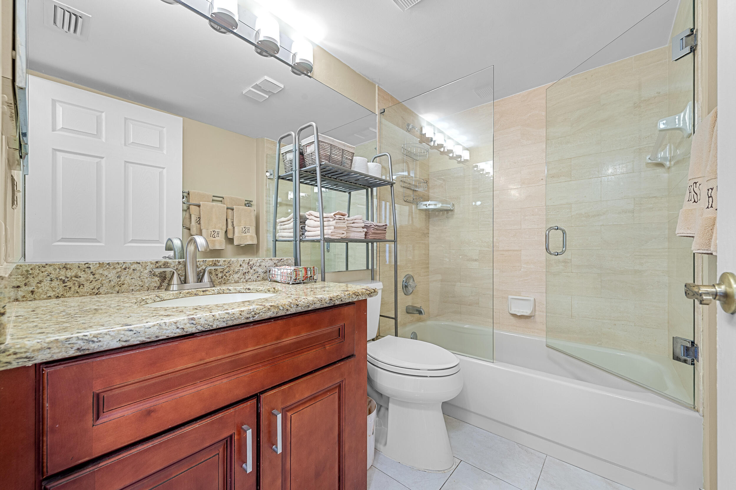 7209 Promenade Drive, Unit 201 Boca Raton, FL 33433 - Photo 32 of 41 a bathroom with a granite countertop sink a toilet and shower