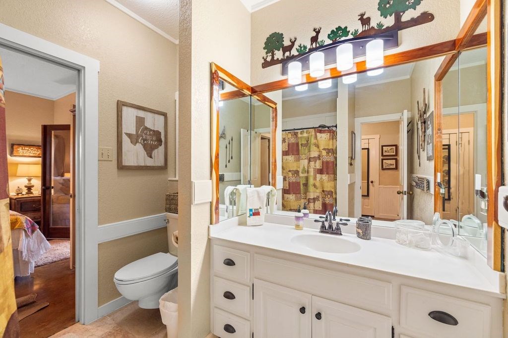 257 Encino Loop Kerrville, TX 78028 - Photo 37 of 92 a bathroom with a sink a toilet a large mirror and shower