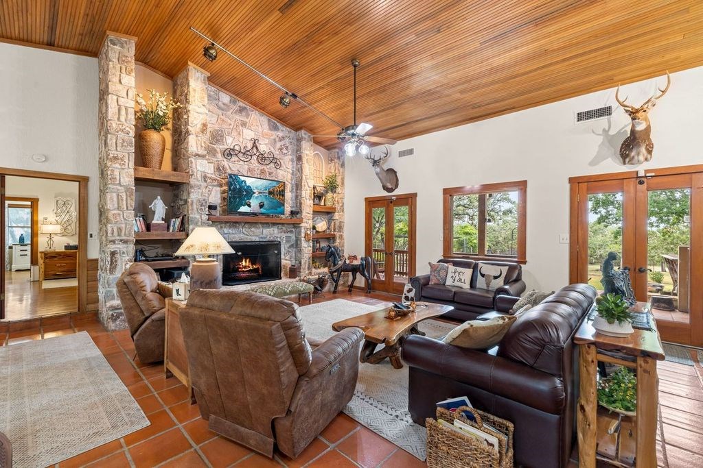 257 Encino Loop Kerrville, TX 78028 - Photo 4 of 92 a living room with furniture a large window and a fireplace