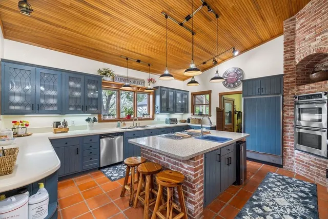 a kitchen with stainless steel appliances granite countertop a stove a sink dishwasher and cabinets with wooden floor