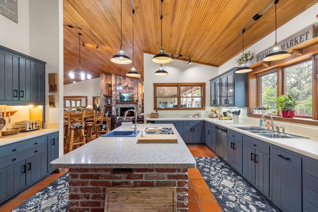 257 Encino Loop Kerrville, TX 78028 - Photo 10 of 92 a kitchen with stainless steel appliances granite countertop a stove a sink dishwasher and cabinets with wooden floor