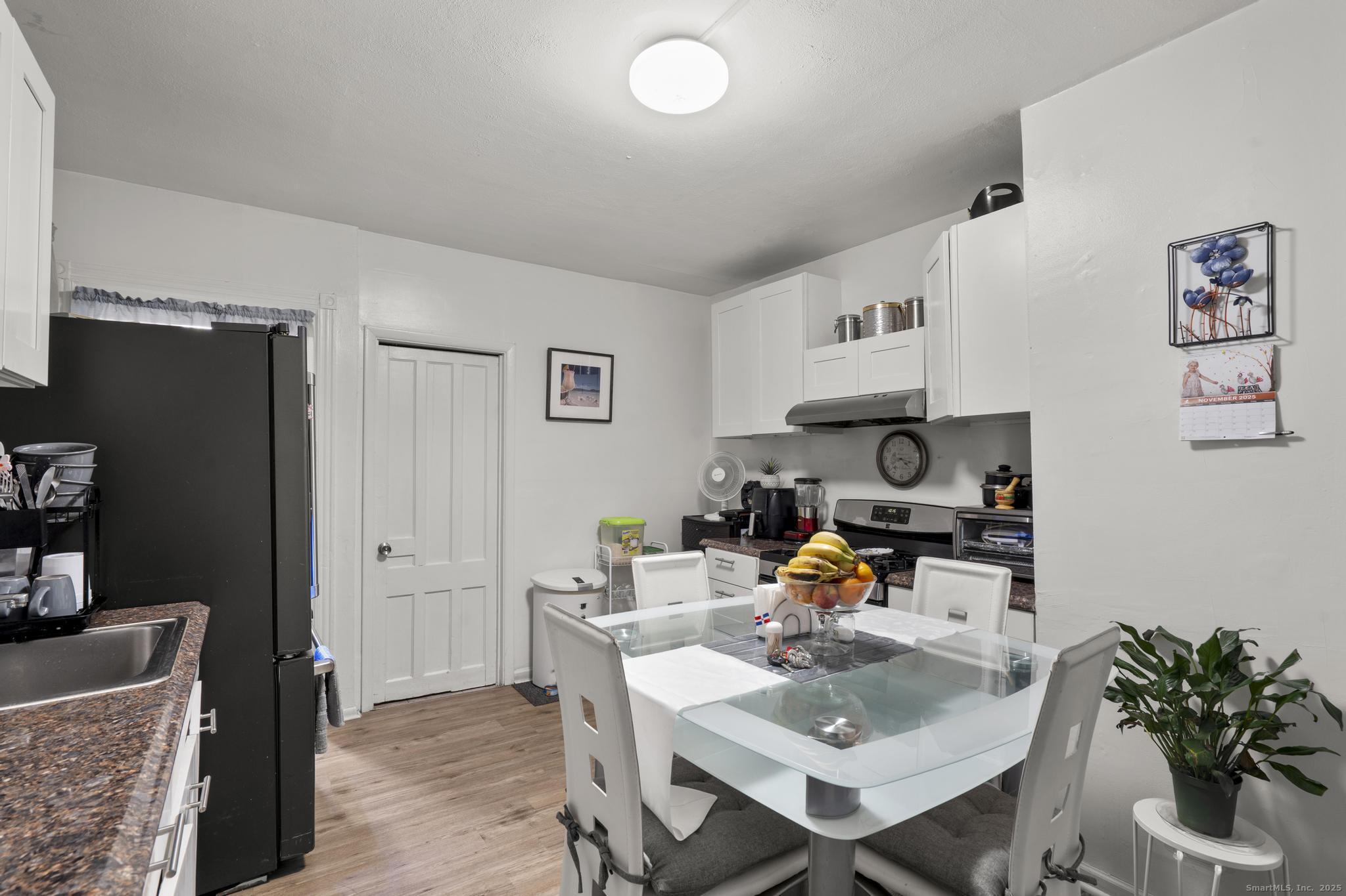 865 Iranistan Avenue Bridgeport, CT 06605 - Photo 13 of 35 a living room with furniture and a dining table with wooden floor