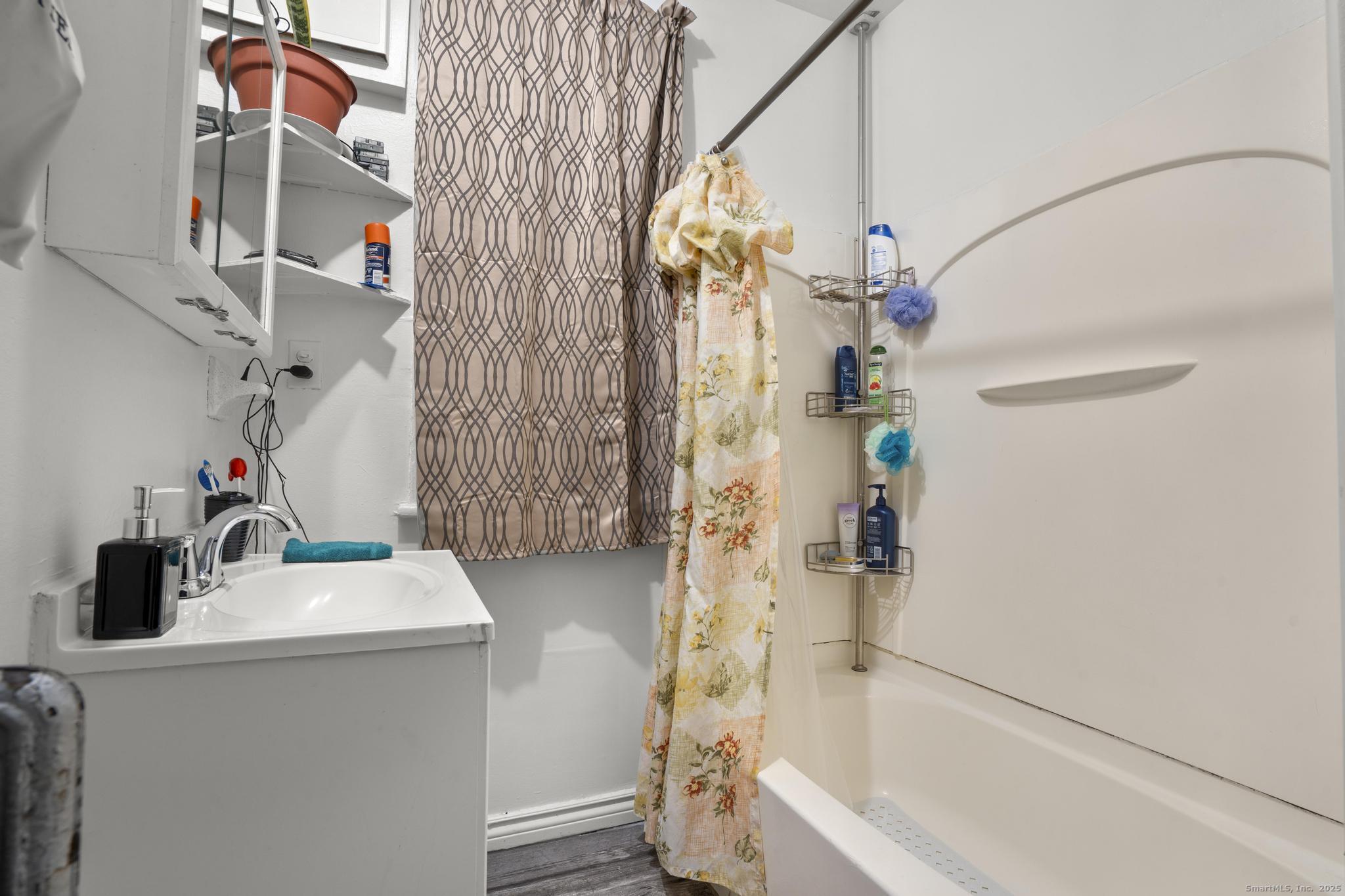 865 Iranistan Avenue Bridgeport, CT 06605 - Photo 19 of 35 a bathroom with a sink and mirror with bathtub