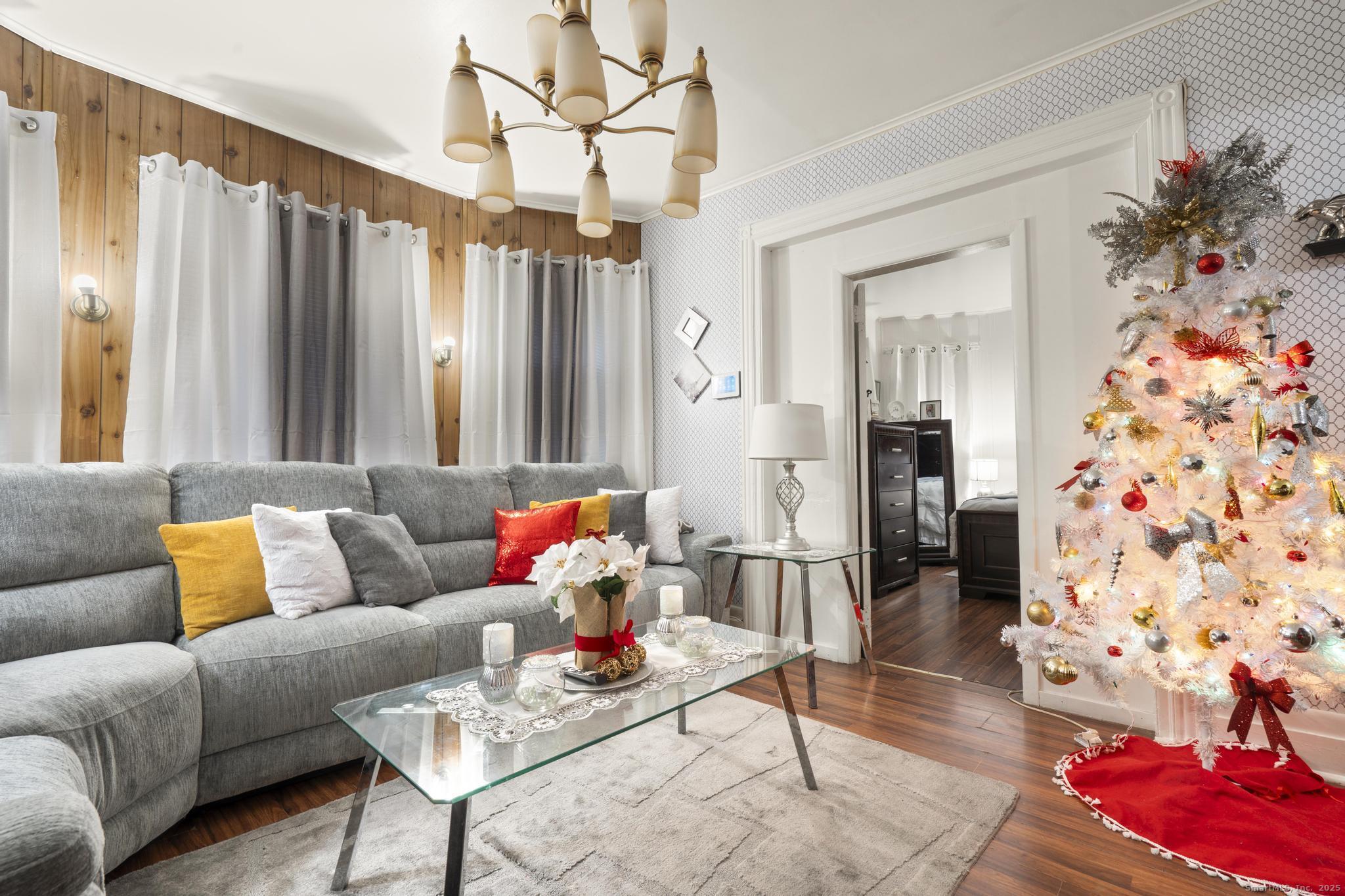 865 Iranistan Avenue Bridgeport, CT 06605 - Photo 8 of 35 a living room with furniture and a chandelier