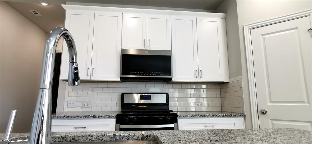 2131 Erika Lane Forney, TX 75126 - Photo 8 of 20 a kitchen with stainless steel appliances a stove a sink and a microwave