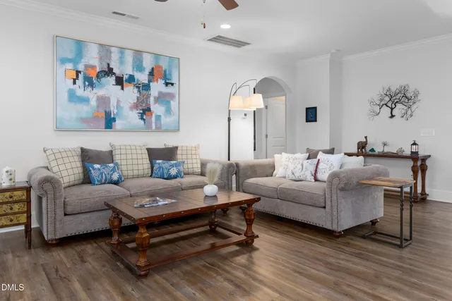a living room with furniture and a painting on the wall