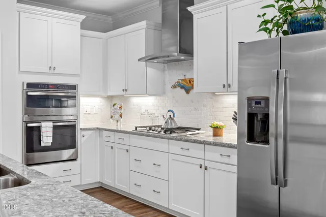 a kitchen with stainless steel appliances kitchen island a refrigerator sink and cabinets