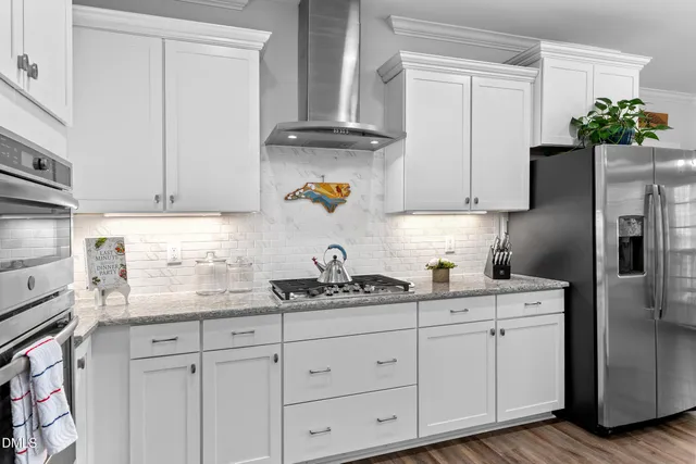 a kitchen with cabinets stainless steel appliances a sink and wooden floor