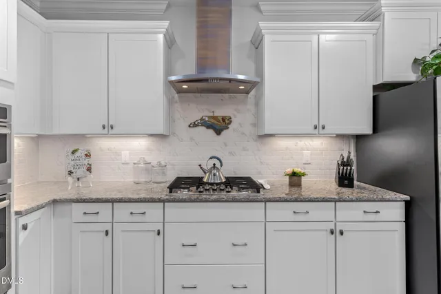 a kitchen with white cabinets and a stove