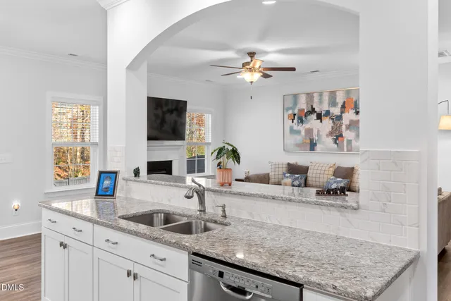 a kitchen with a sink a counter top space and living room area