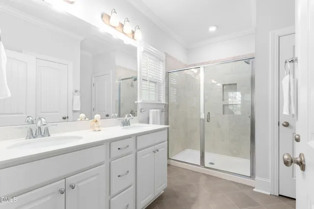 a bathroom with a double vanity sink mirror and shower