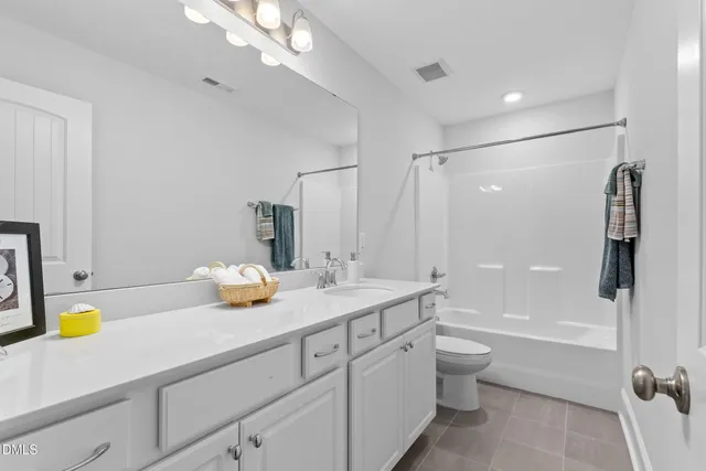 a bathroom with a granite countertop sink a toilet and shower
