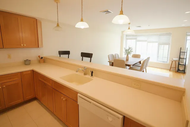 a kitchen with a sink a counter and chairs