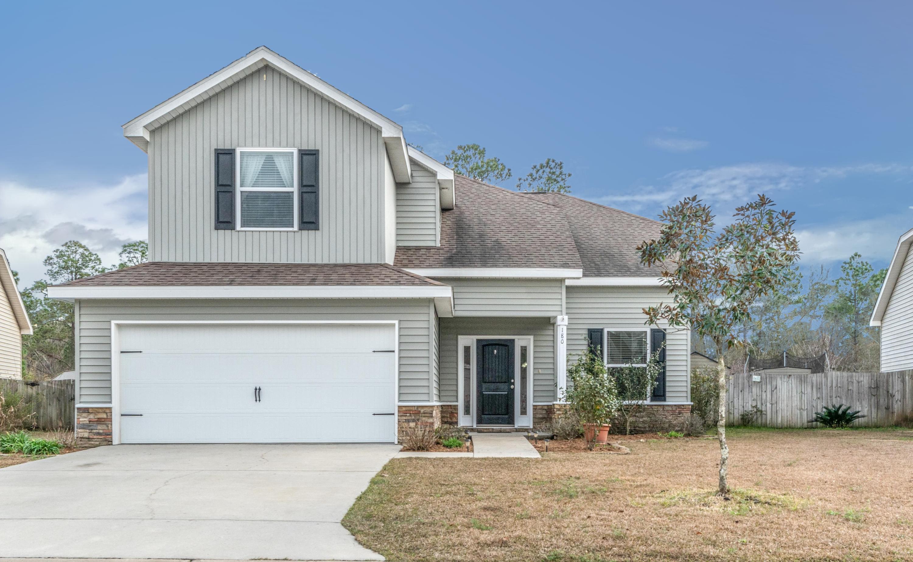 180 Peoria Boulevard Crestview, FL 32536 - Photo 2 of 33 a front view of a house with a yard and garage