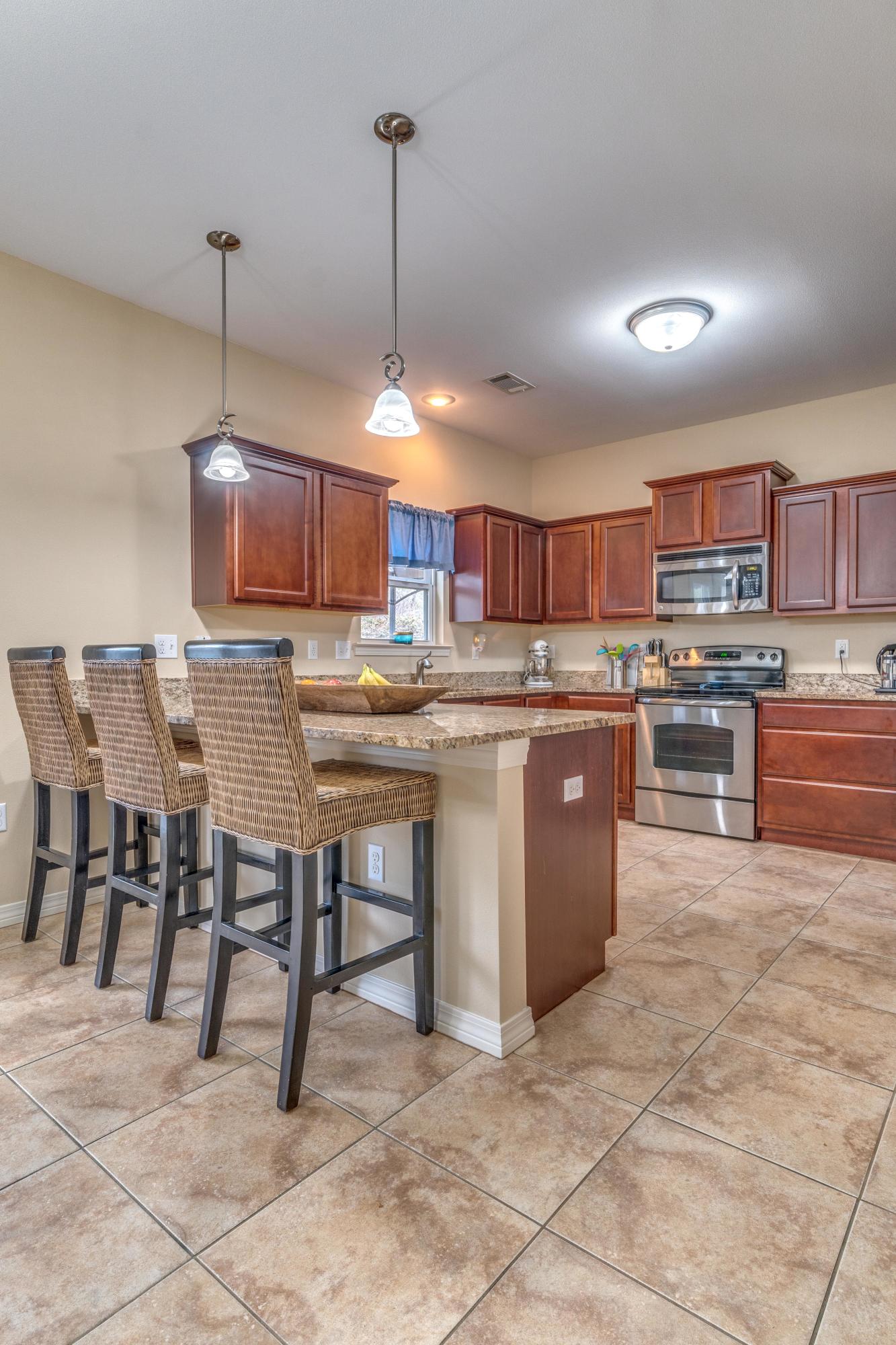 180 Peoria Boulevard Crestview, FL 32536 - Photo 6 of 33 a kitchen with kitchen island a stove a table and chairs in it