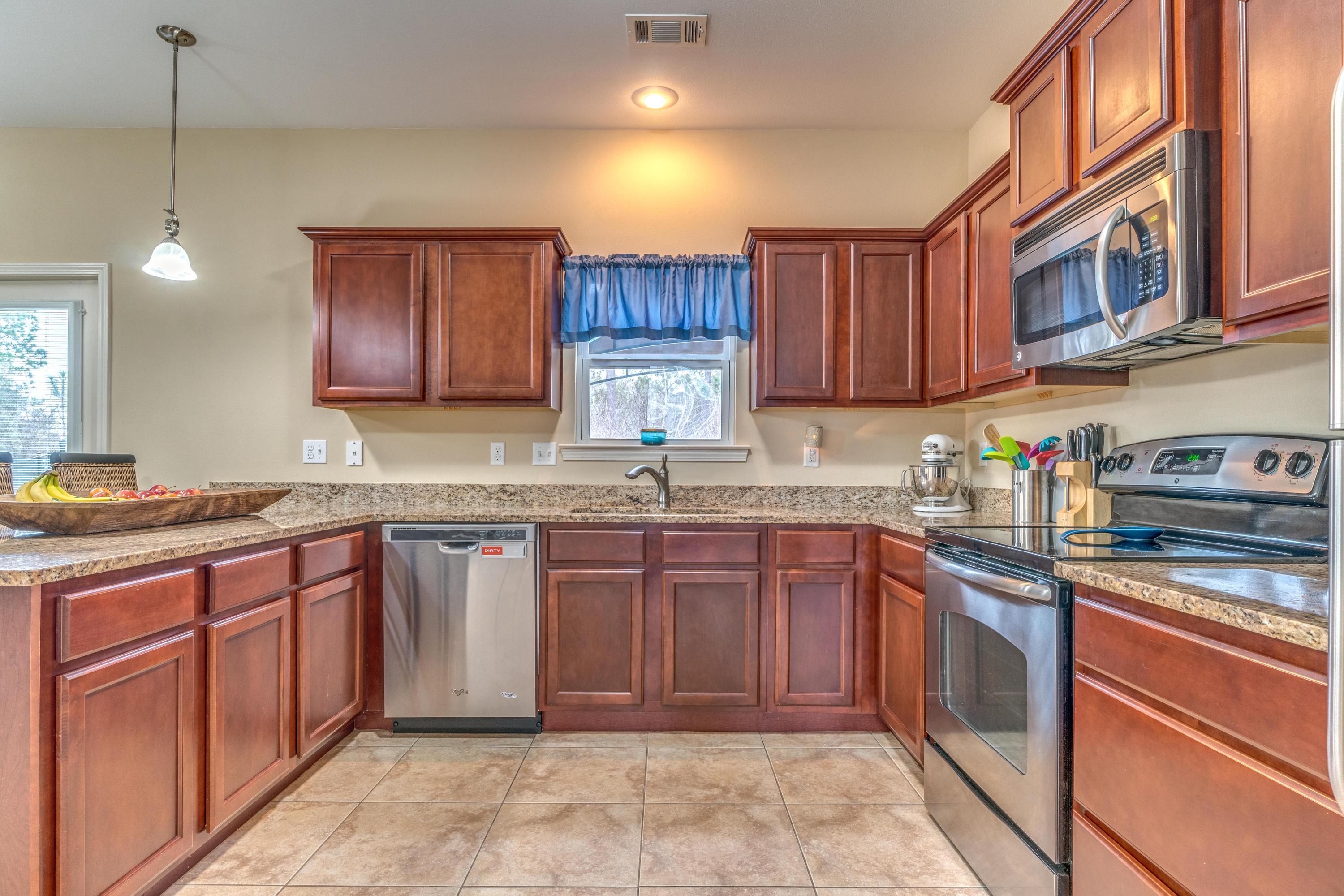 180 Peoria Boulevard Crestview, FL 32536 - Photo 7 of 33 a kitchen with stainless steel appliances granite countertop wooden cabinets a sink and dishwasher