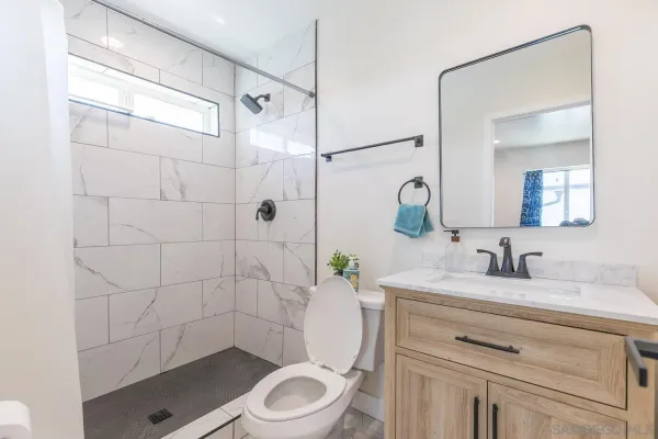 a bathroom with a sink a toilet and shower