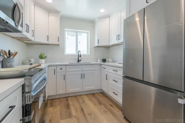 a kitchen with stainless steel appliances a refrigerator sink and cabinets