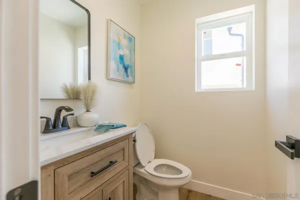 a bathroom with a granite countertop toilet sink and mirror
