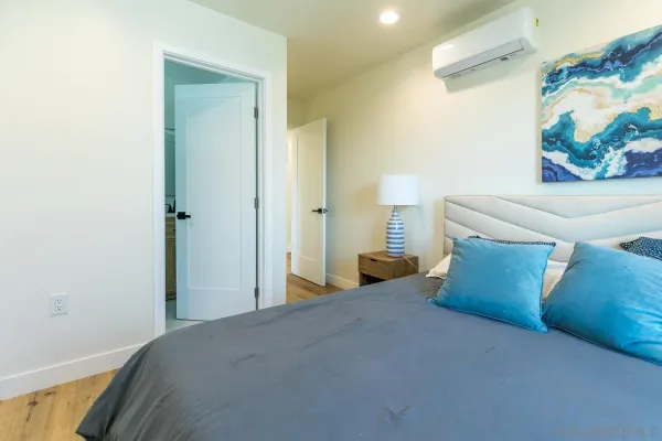 a bed room with a bed and a painting on the wall