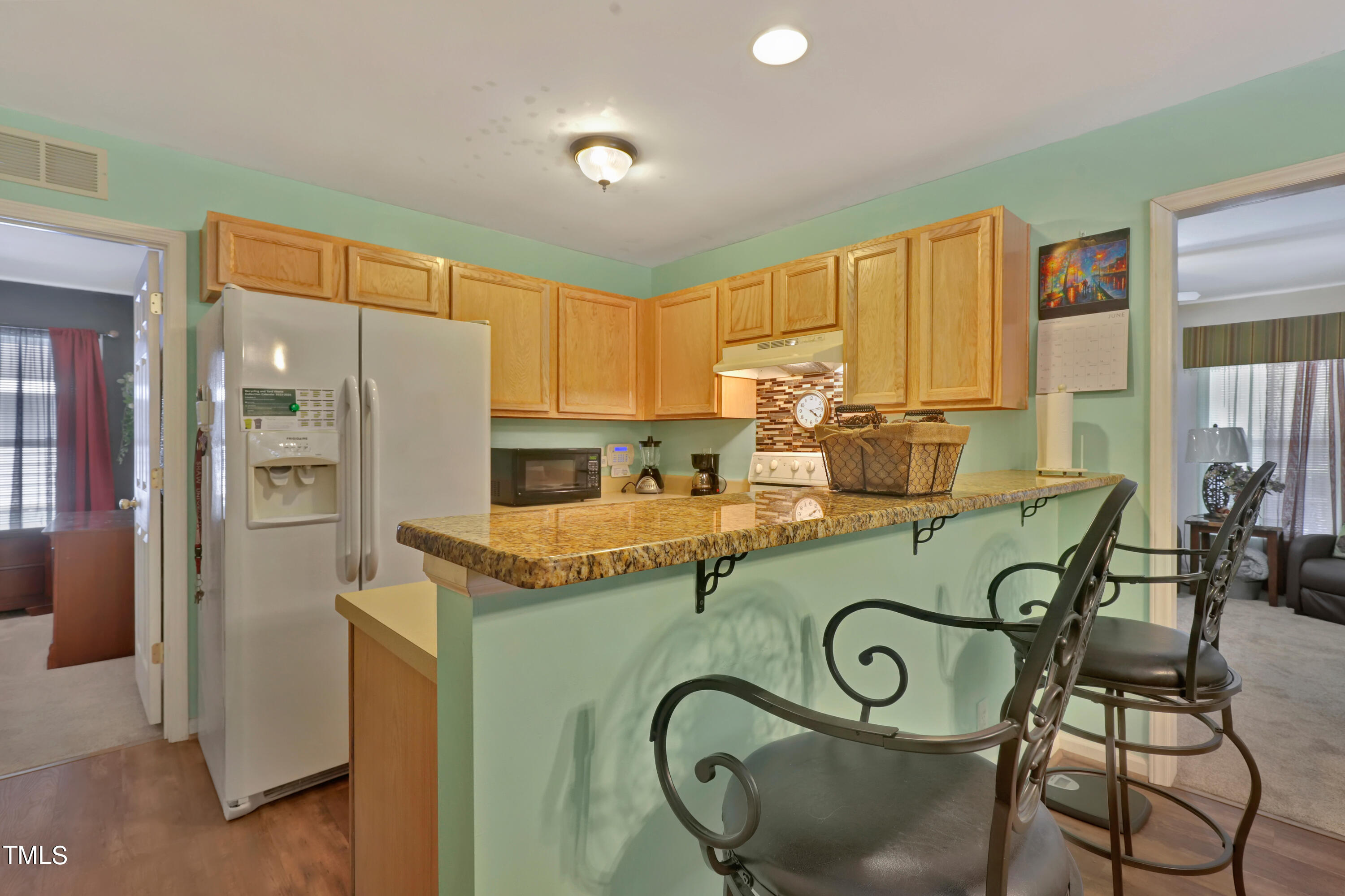 603 East Martin Street Raleigh, NC 27601 - Photo 7 of 25 a kitchen with granite countertop a table chairs refrigerator and cabinets