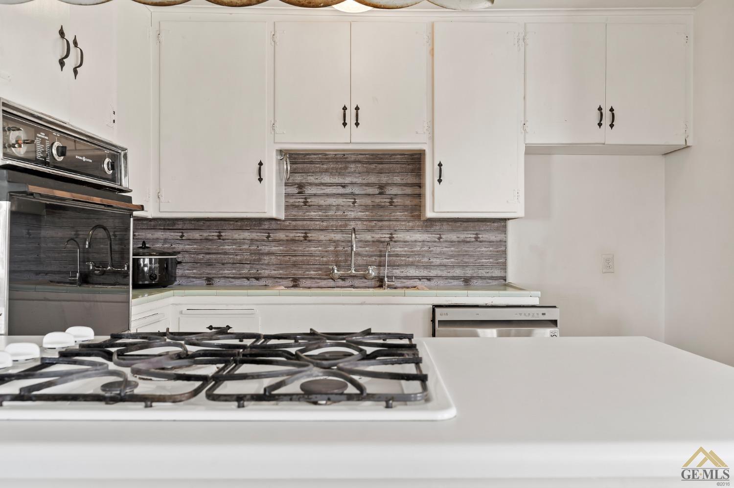 Undisclosed Address Wasco, CA 93280 - Photo 7 of 30 a kitchen with granite countertop a stove sink and cabinets